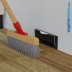 Accompagnamento bricione, sporco e polveri a pavimento con scopa verso bocchetta aspirante battiscopa installata a parete, Vacmic nera